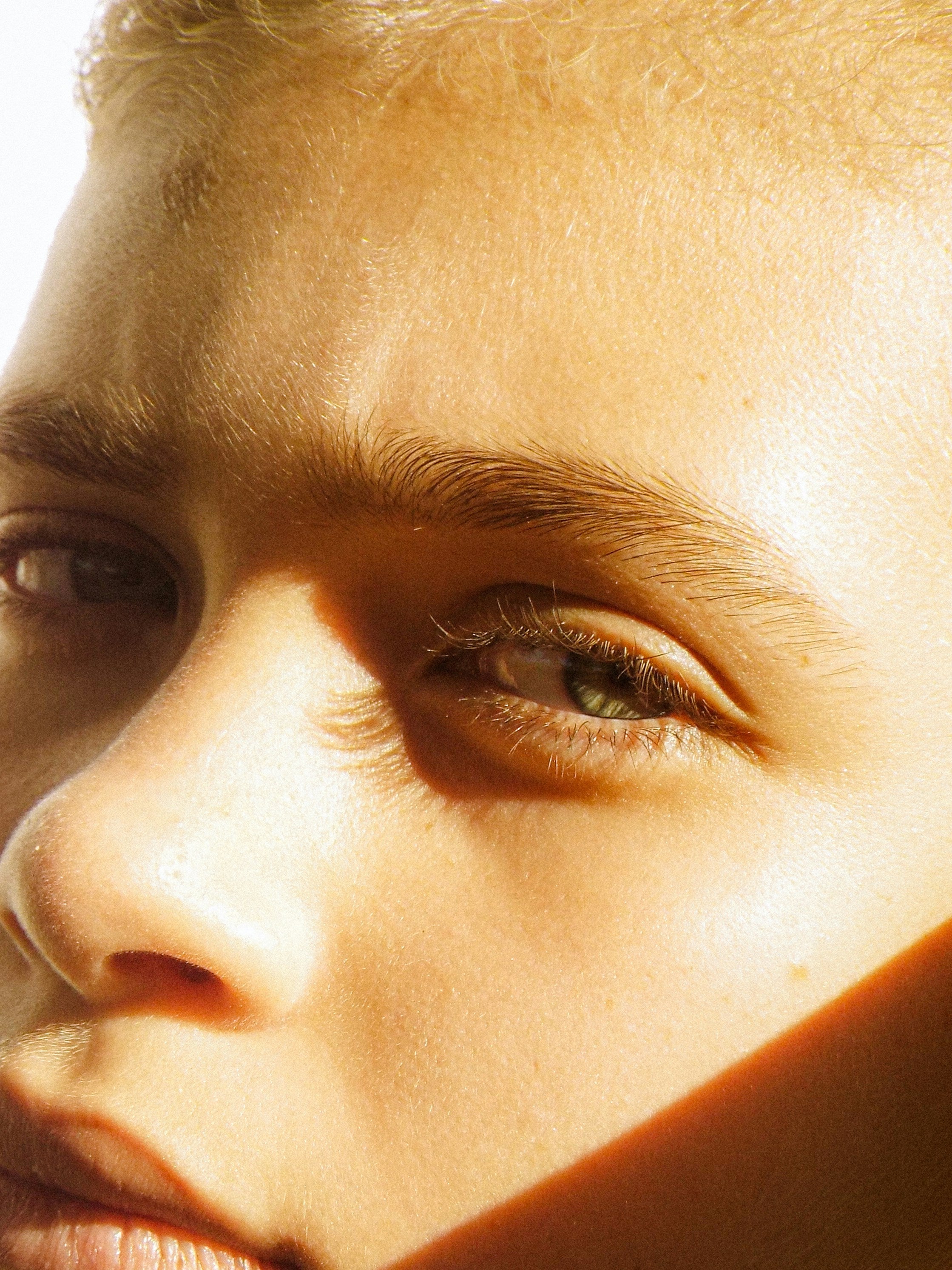 Persons with short blonde hare with bright sunlight casting shadows on their face